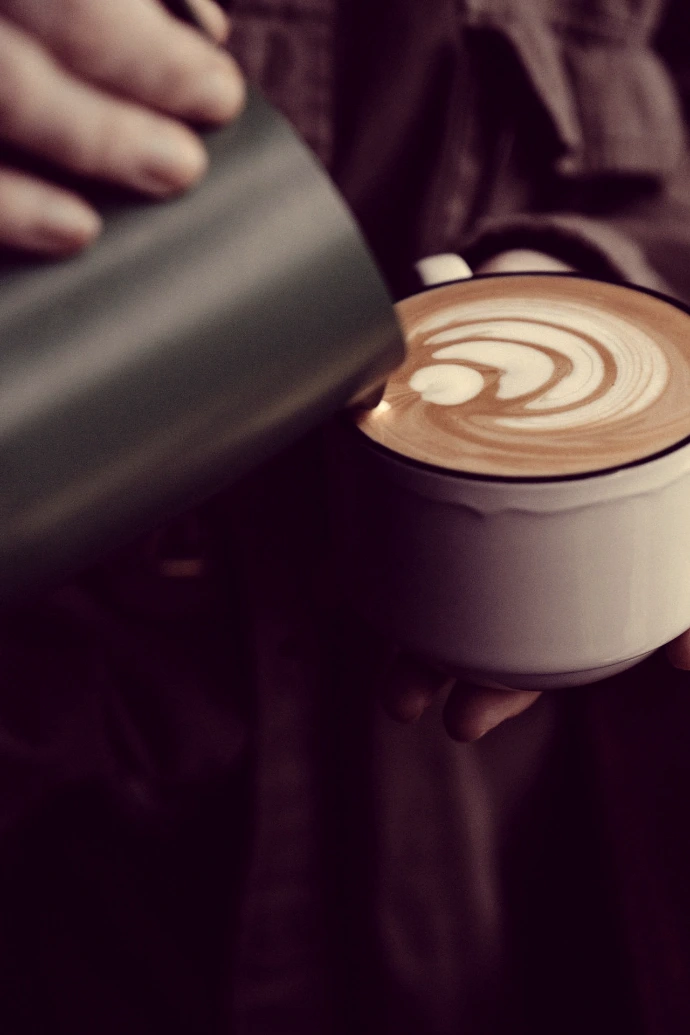 a person holding a cup of coffee in their hands